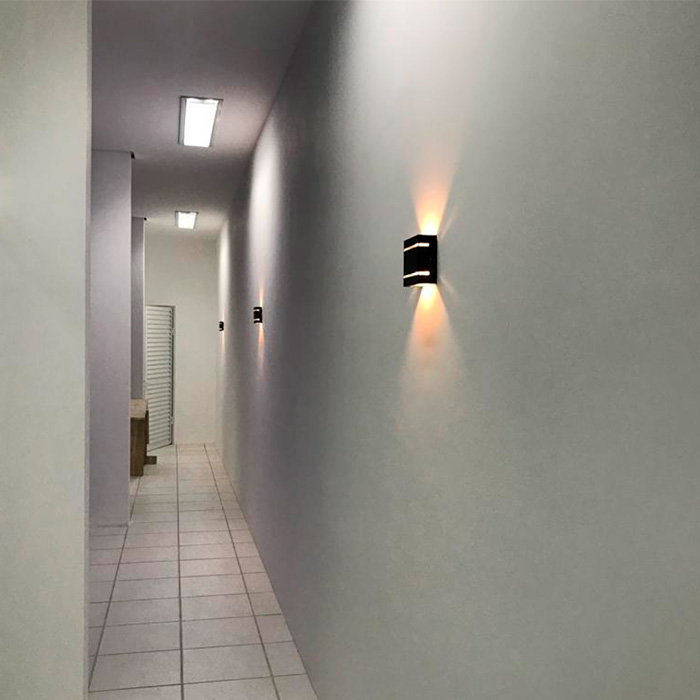 Corredor com parede branca e luminária